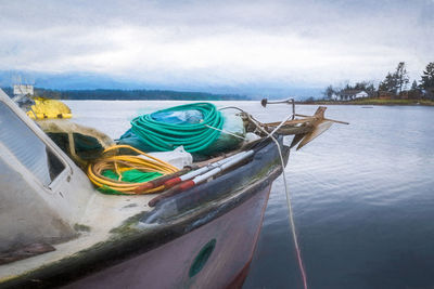 Boat moored on beach against sky