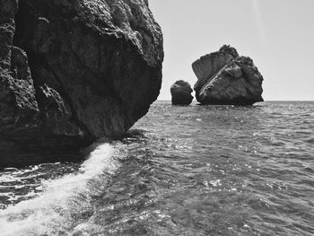 Rock formation in sea against sky