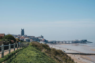 View of buildings by river against sky