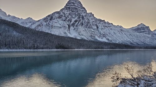 Scenic view of lake and snowcapped mountains against sky