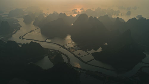 Aerial view of mountain range against sky during sunset