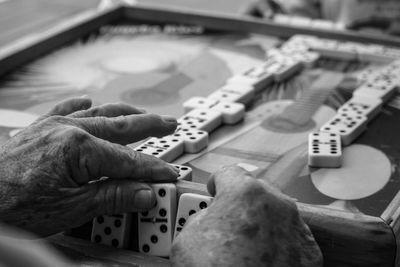 Cropped hand playing with dices on table