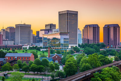 Buildings in city against sky during sunset