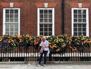 Full length of woman standing by building