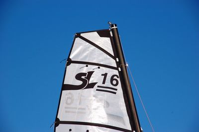Low angle view of information sign against clear blue sky