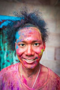Portrait of young man covered with powder paint during holi