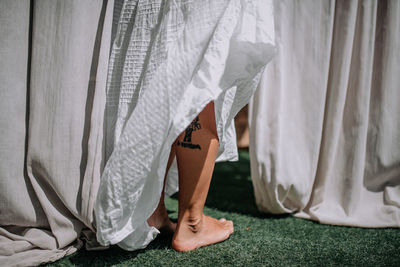 Low section of women standing on bed