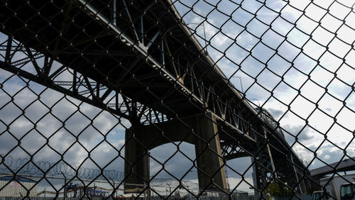 Low angle view of chainlink fence against sky