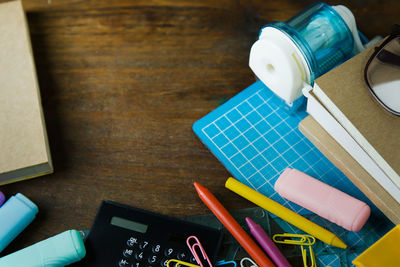 Paper clips with pens and books on table