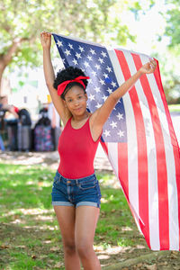 Portrait of young woman holding american flag