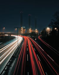 Light trails on road against sky at night