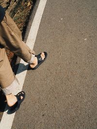 Low section of man standing on road