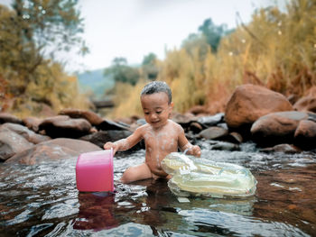 Boy playing with rocks in water