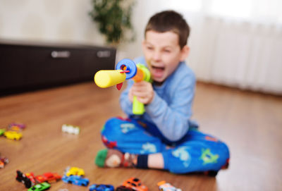 A foam bullet or rocket flies out of a toy machine gun.