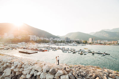 Man standing on rocks in city against clear sky