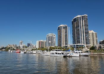 Modern buildings in city against clear blue sky