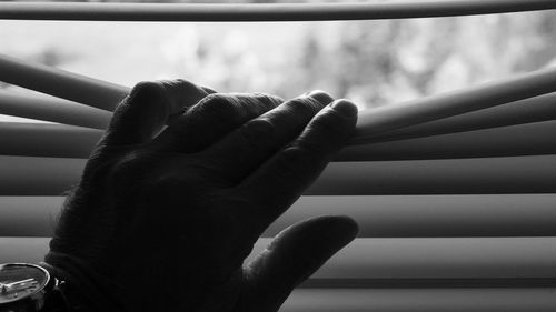 Close-up of hand touching window