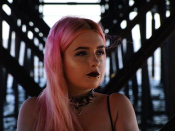 Close-up of beautiful woman with dyed hair looking away while sitting outdoors