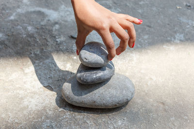 Cropped image of hand stacking pebbles