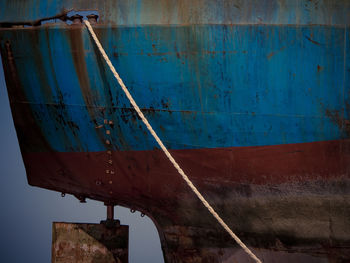 Rusty metallic boat against blue wall