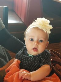 Portrait of cute baby girl sitting at home