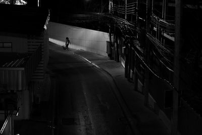 Man walking on street amidst buildings at night