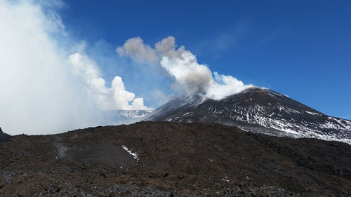 Smoke emitting from volcanic mountain against sky