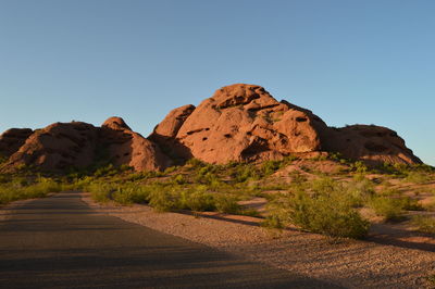 Road amidst desert against clear sky