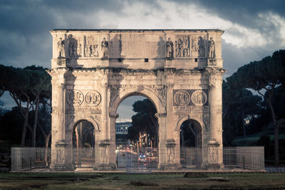 Arch of constantine against cloudy sky at dusk