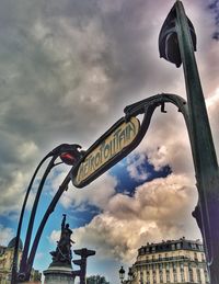 Low angle view of road sign against sky in city