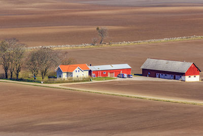 Houses on field by road against sky