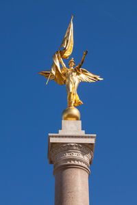 Low angle view of statue of liberty against blue sky