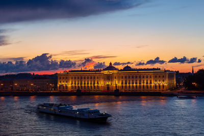 Illuminated russian academy of arts in saint petersburg, russia. blurred drifting boat