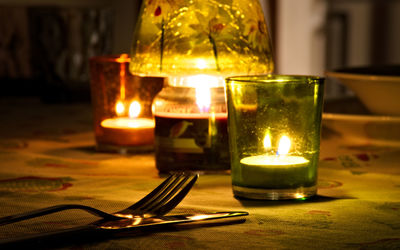 Close-up of illuminated tea light candle on table