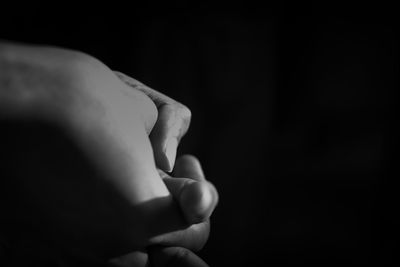 Close-up of hand against black background