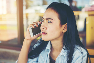 Portrait of young woman using mobile phone