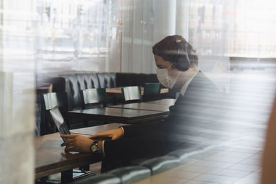 Man wearing face mask working at cafe