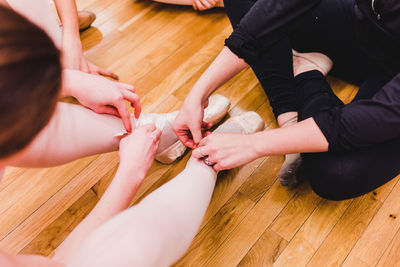 Low section of ballet dancers on hardwood floor