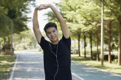 Full length of young man standing against trees