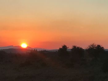 Scenic view of landscape against orange sky