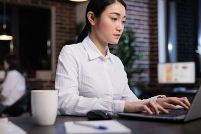 Businesswoman using laptop at office