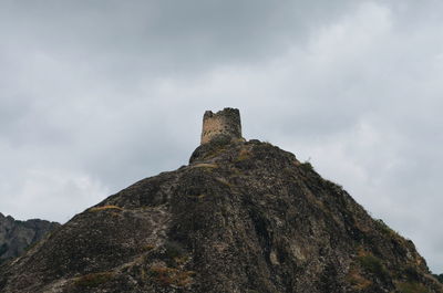 Low angle view of rocks on mountain against sky