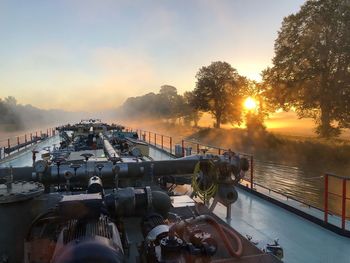 High angle view of cropped tanker on river against sky during sunset