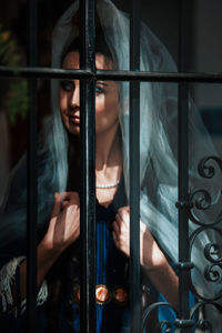 Portrait of a young woman looking down on metal