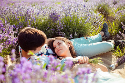 Portrait of friends lying on purple flowering plants