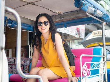 Portrait of a smiling young woman sitting outdoors