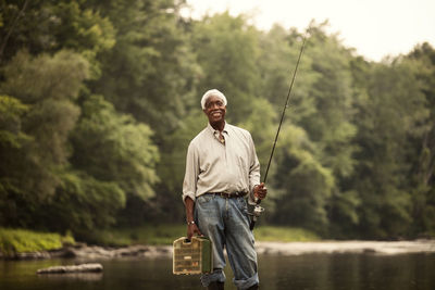 Portrait of man standing against trees