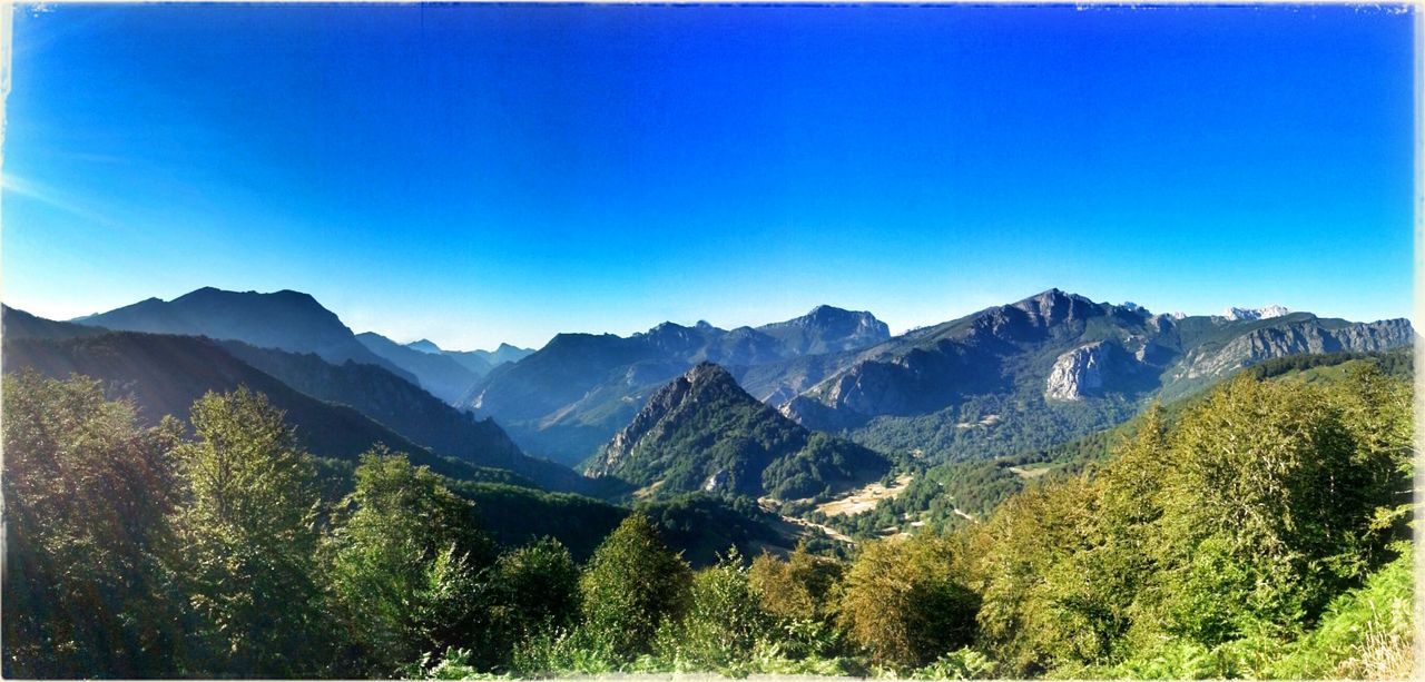 mountain, mountain range, tranquil scene, tranquility, scenics, clear sky, beauty in nature, landscape, blue, nature, copy space, non-urban scene, idyllic, tree, remote, green color, day, outdoors, countryside, sunlight