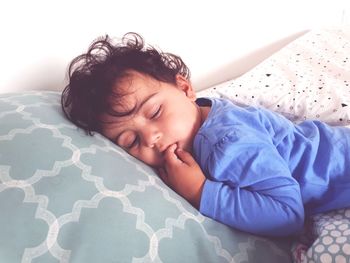 Close-up of cute baby sleeping on bed at home