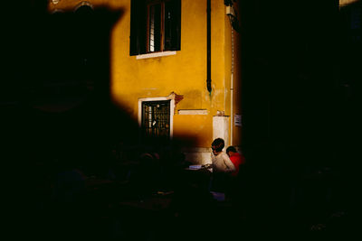 People sitting in front of building at night